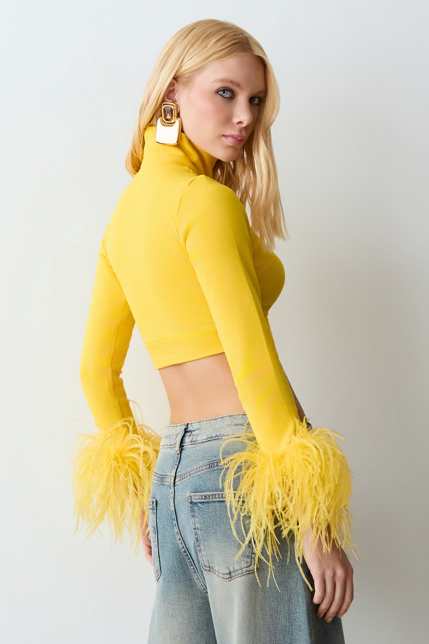 CROPPED MANGA LONGA GOLA ALTA COM PLUMAS NO PUNHO AMARELO OURO