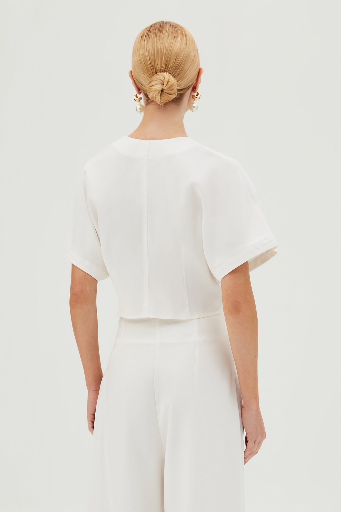 BLUSA MANGA CURTA COM BARRA ASSIMETRICA E BOTOES OFF WHITE