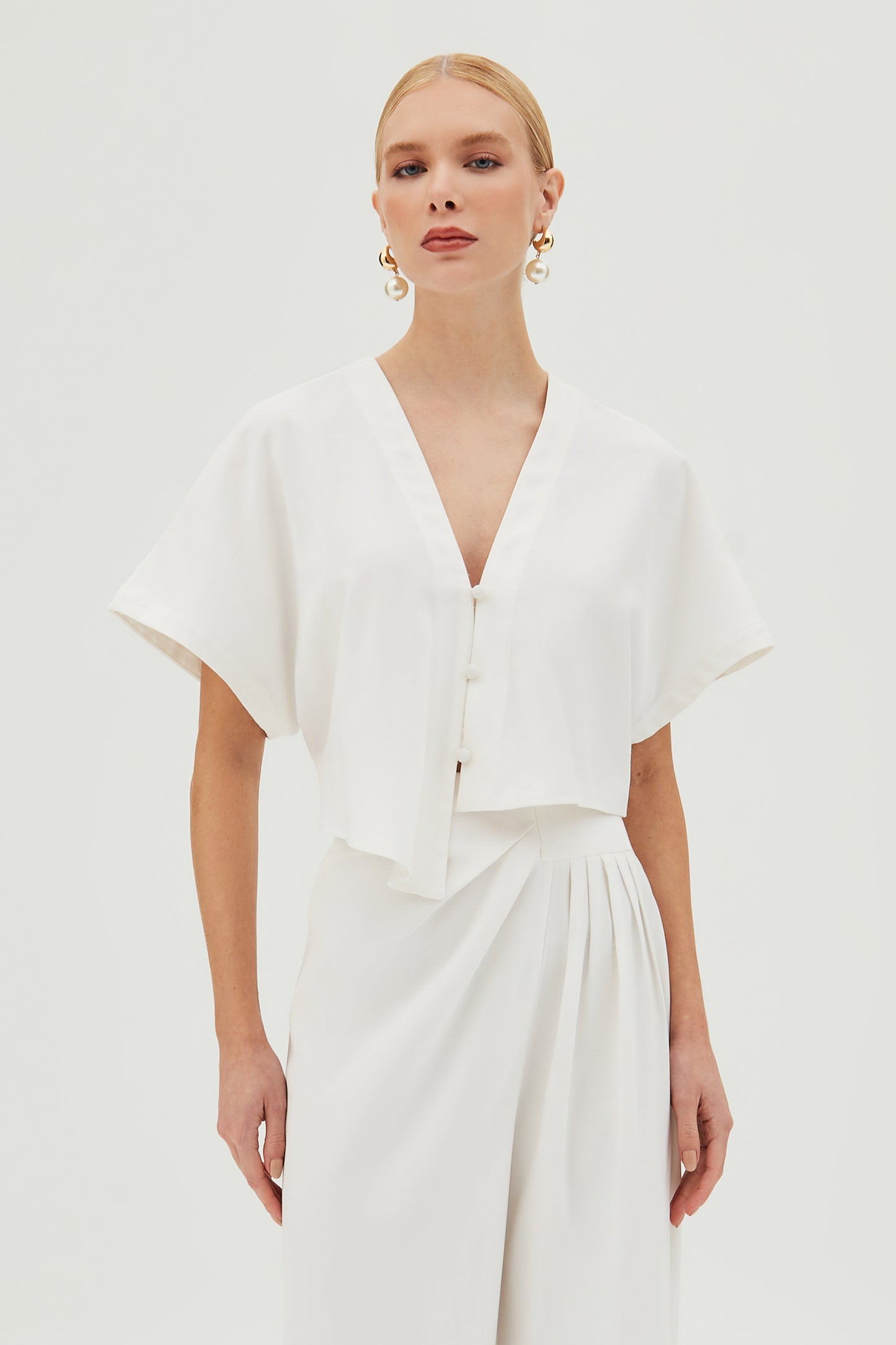 BLUSA MANGA CURTA COM BARRA ASSIMETRICA E BOTOES OFF WHITE